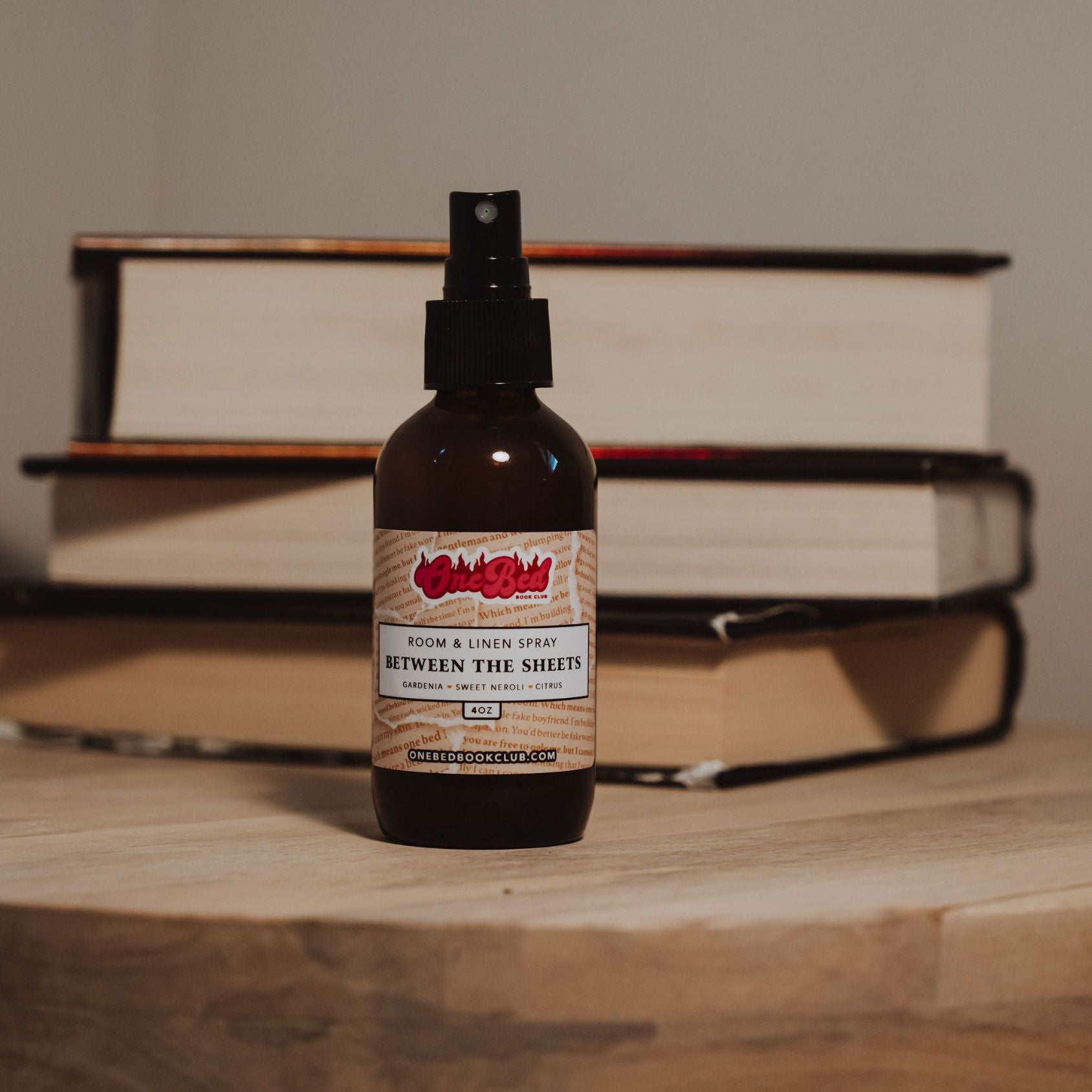 Room spray bottle in focus with open book pages blurred in the background.