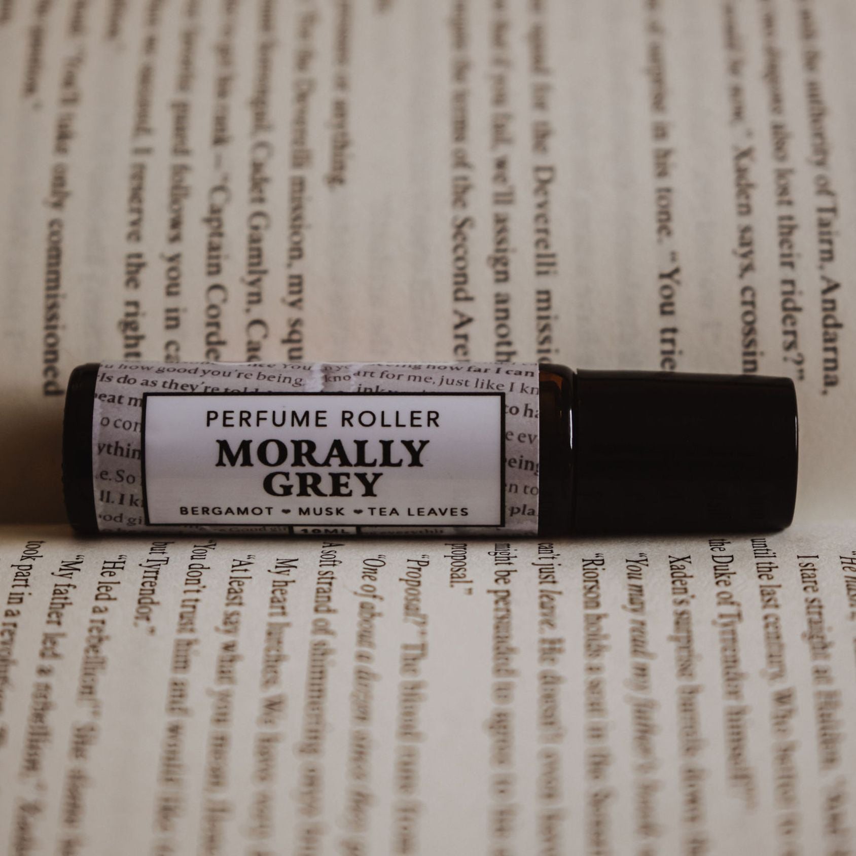 Angled shot of “Morally Grey” roller with sharp focus on label and blurred text background.
