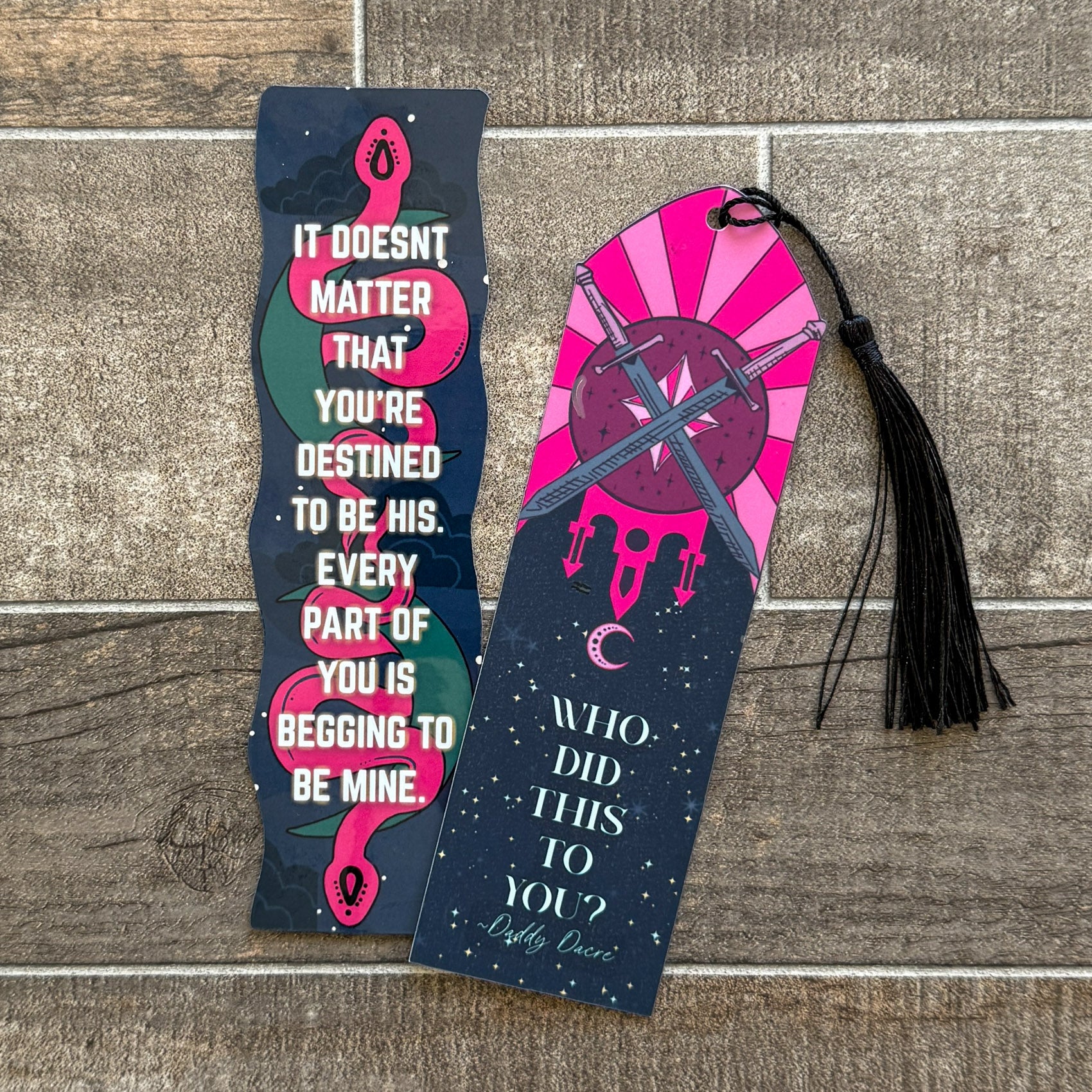 Two bookmarks inspired by Holly Renee’s fantasy books. One features a pink serpent and quote from Stars and Shadows. The other has crossed swords and a moon with “Who did this to you?” quote from The Veiled Kingdom.